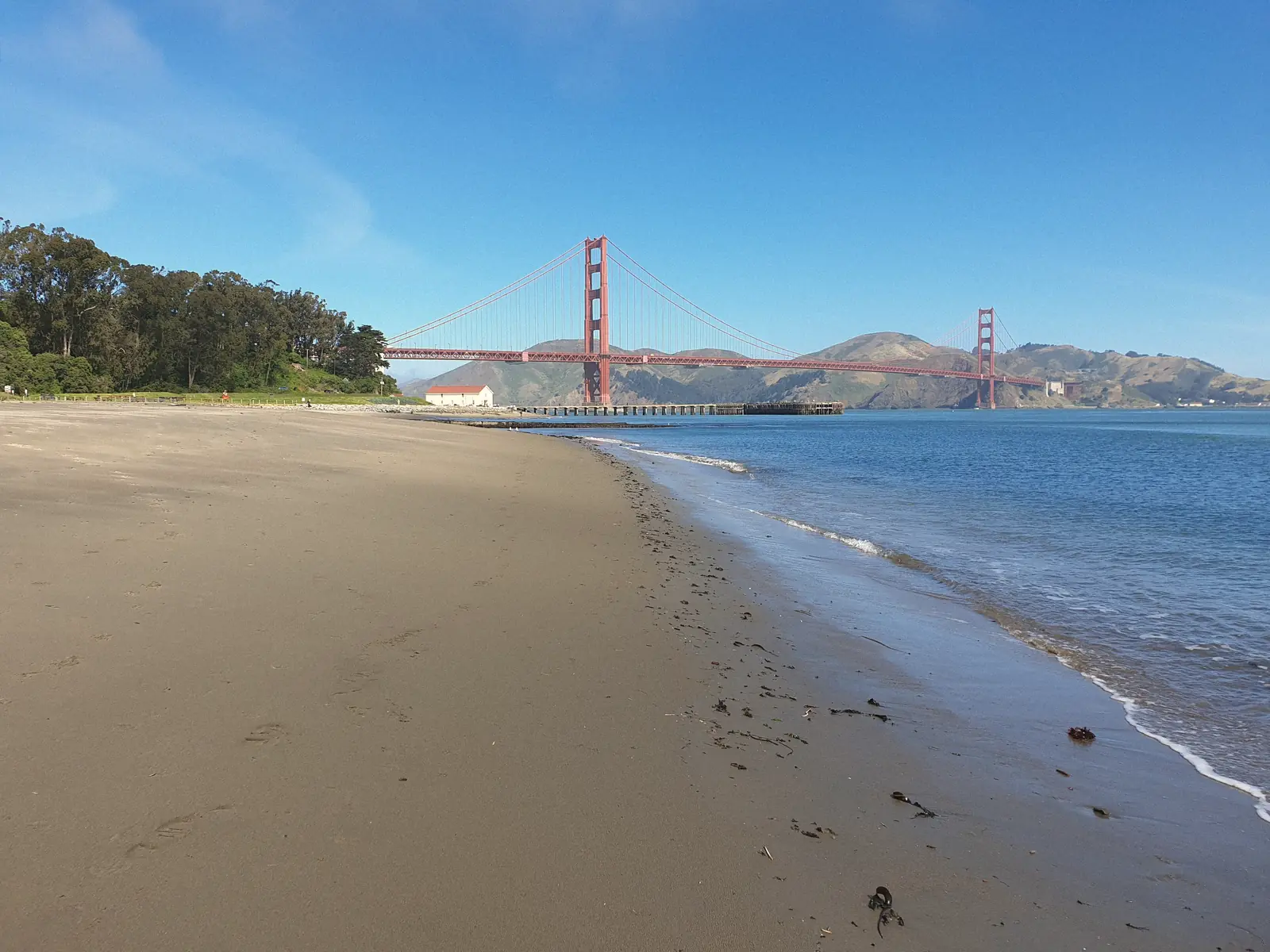 Photo of the sandy shore at Crissy Field with the Golden Gate Bridge behind